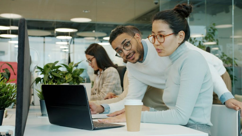 Đồng nghiệp trao đổi trên laptop tại văn phòng
